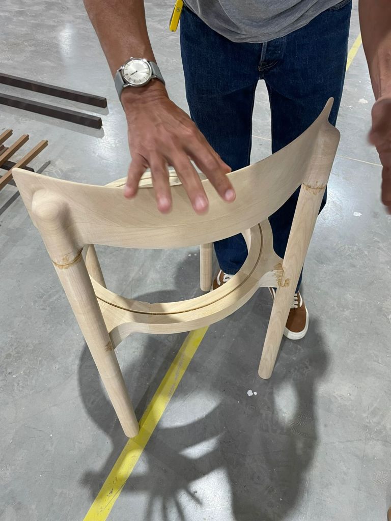 Jequitibá hardwood chair prototype inside a Brazilian furniture factory during product development and wood conditioning evaluation.