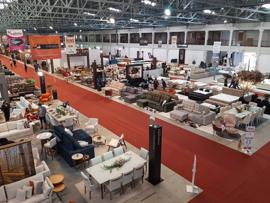Modern upholstered sofas and contemporary casegoods exhibited by Brazilian furniture manufacturers inside the Movelsul pavilion.